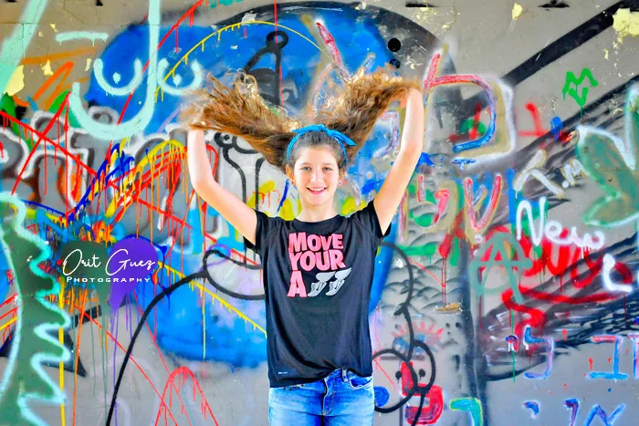 נערה בצילומי בוק על רקע קיר גרפיטי